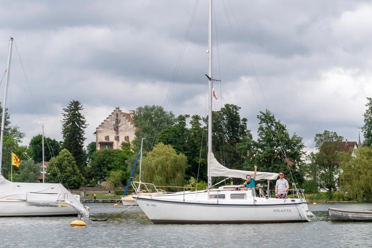 Zwei Männer auf dem Boot, einer winkt.
